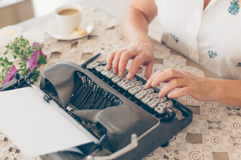 Older lady typing on typewriter in house in white shirt during daytime . . La beauté commence par vos differences